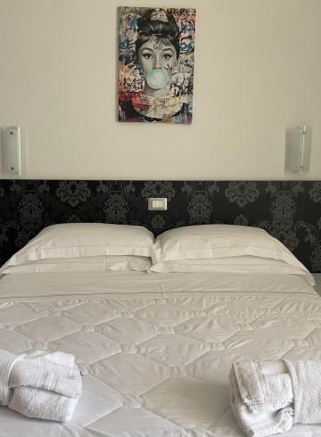 Bedroom with double bed and wall art.