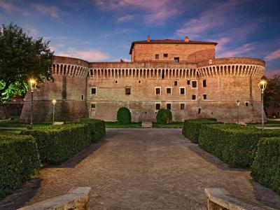 Medieval castle with towers and imposing walls at sunset.