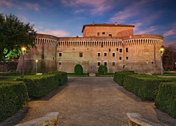 Medieval castle with towers and imposing walls at sunset.