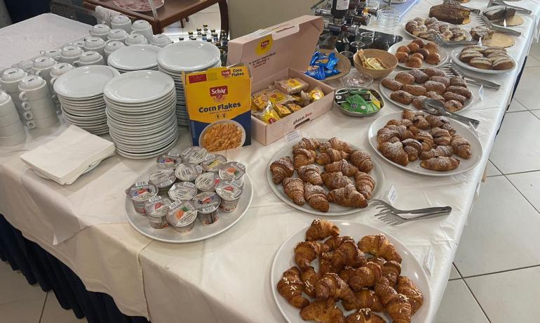 Frühstücksbuffet mit Croissants, Müsli und Marmeladen.