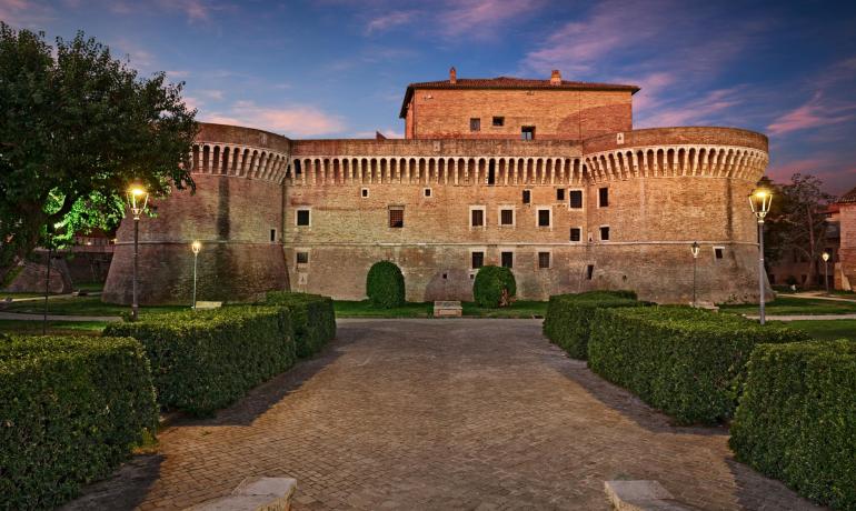 Medieval castle with towers and imposing walls at sunset.