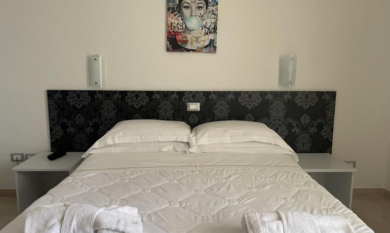 Camera da letto con letto matrimoniale e arte murale.