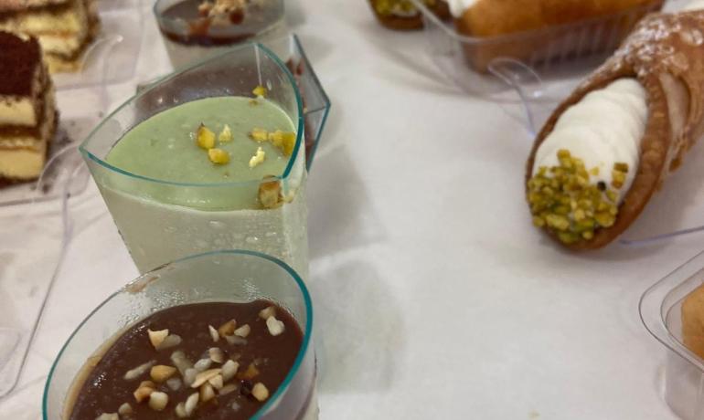 Dolci assortiti con cannoli, babà e mousse.