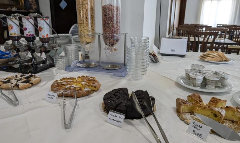 Buffet mit Kuchen, Müsli, Joghurt und Brot.