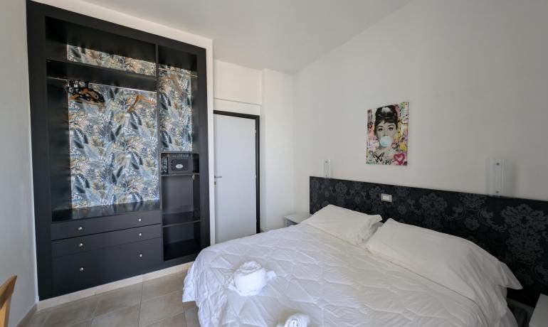 Modern room with double bed and decorated wardrobe.