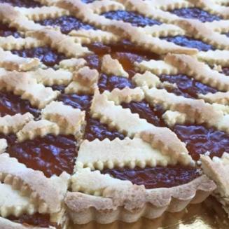 Crostata con marmellata di albicocche e decorazione a griglia di pasta frolla.