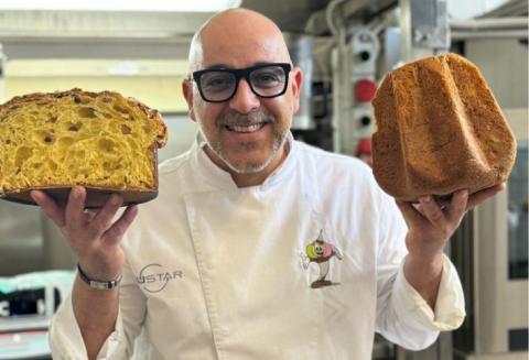 Pasticcere con panettone e pandoro in laboratorio di pasticceria.