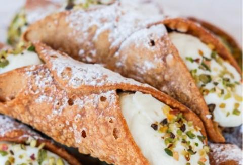 Deliziosi cannoli siciliani con ricotta, pistacchi e zucchero a velo.